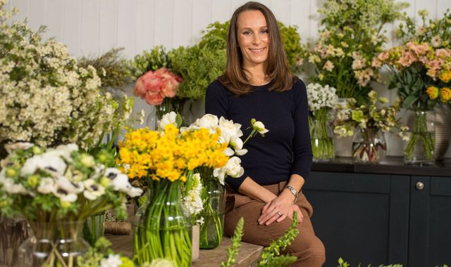 продавец цветов в окружении своей продукции