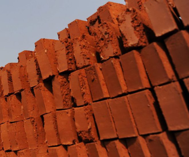 Работник отвозит готовые кирпичи