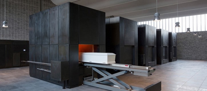 Помещение гроба в печь для кремации