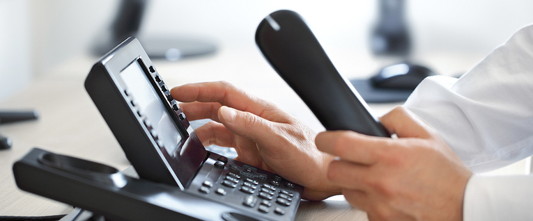 Мужчина набирает номер телефона.