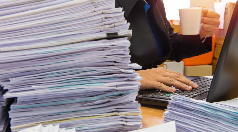 Документы, руки за ноутбуком.