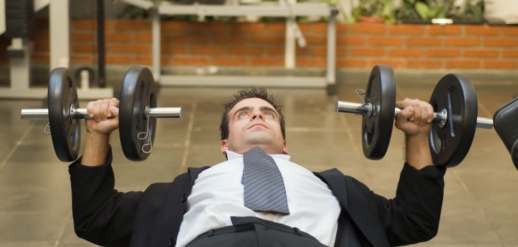 мужчина в галстуке поднимает штанги