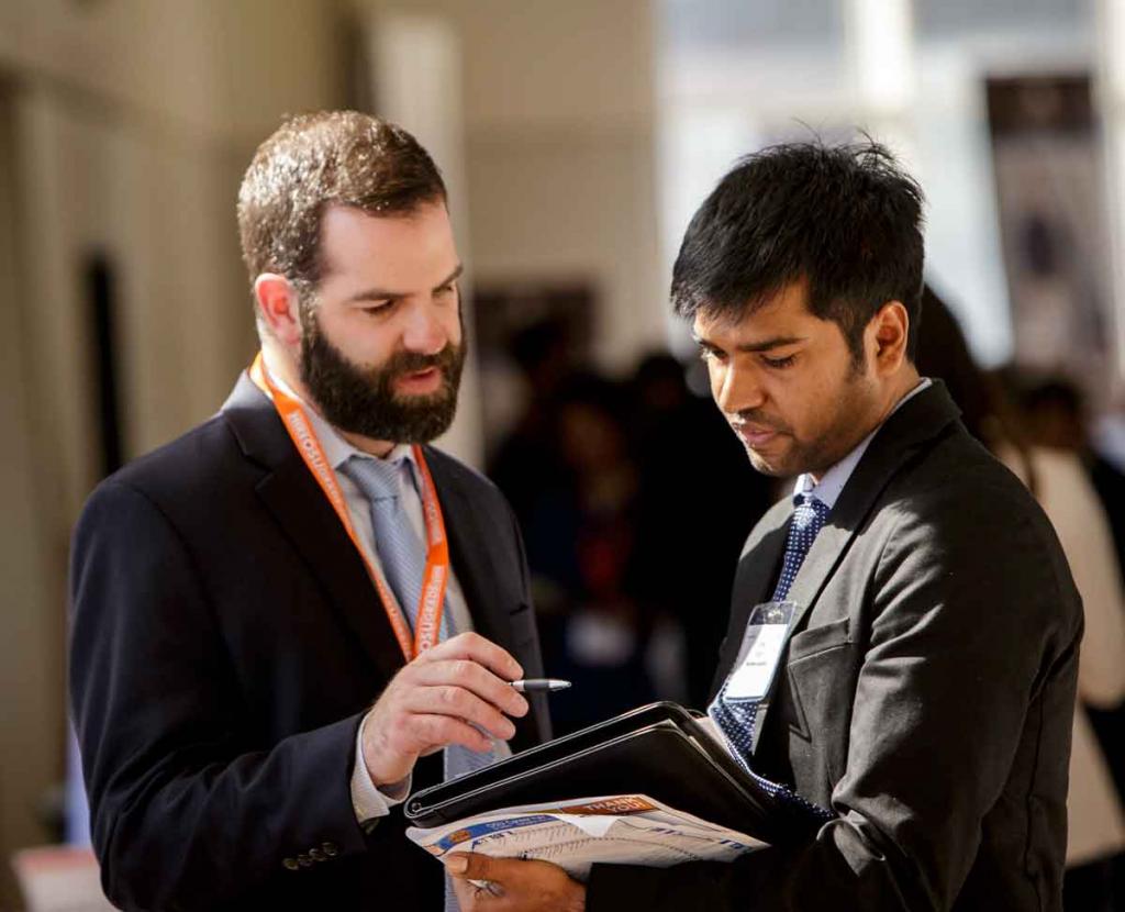 Бородатый мужчина что-то рассказывает студенту.