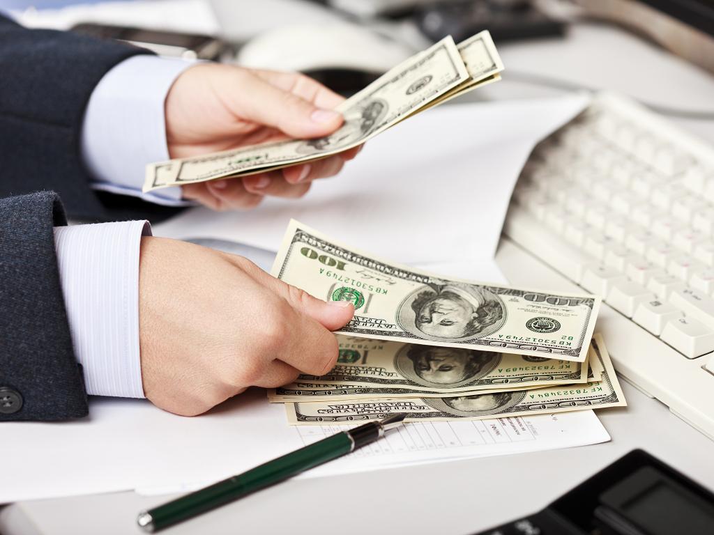 Мужчина пересчитывает доллары.